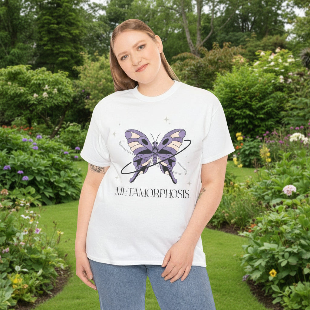 Woman wearing a white t-shirt with a butterfly graphic and 'Metamorphosis' text on in a garden.