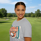 Women wearing a grey t-shirt with a graphic design andgolfing humour text on a golf course.